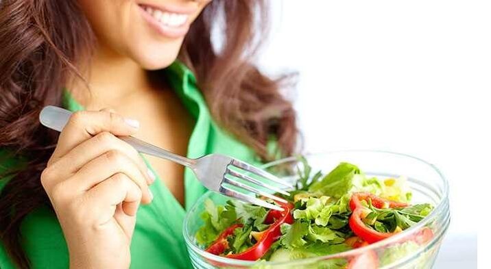 The girl eats a vegetable salad on a protein diet