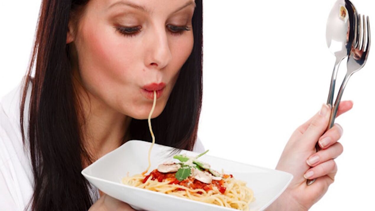 A woman eats spaghetti to slim her belly