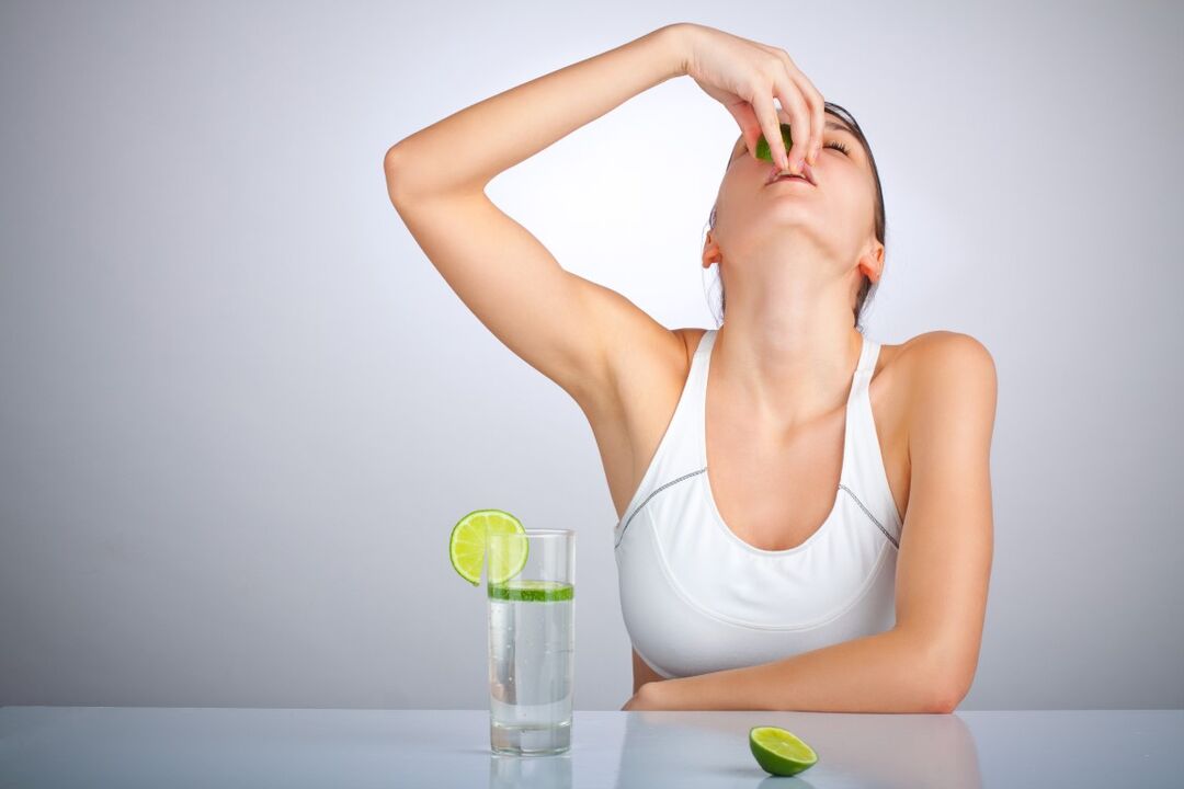 A girl drinks water with lemon to lose weight